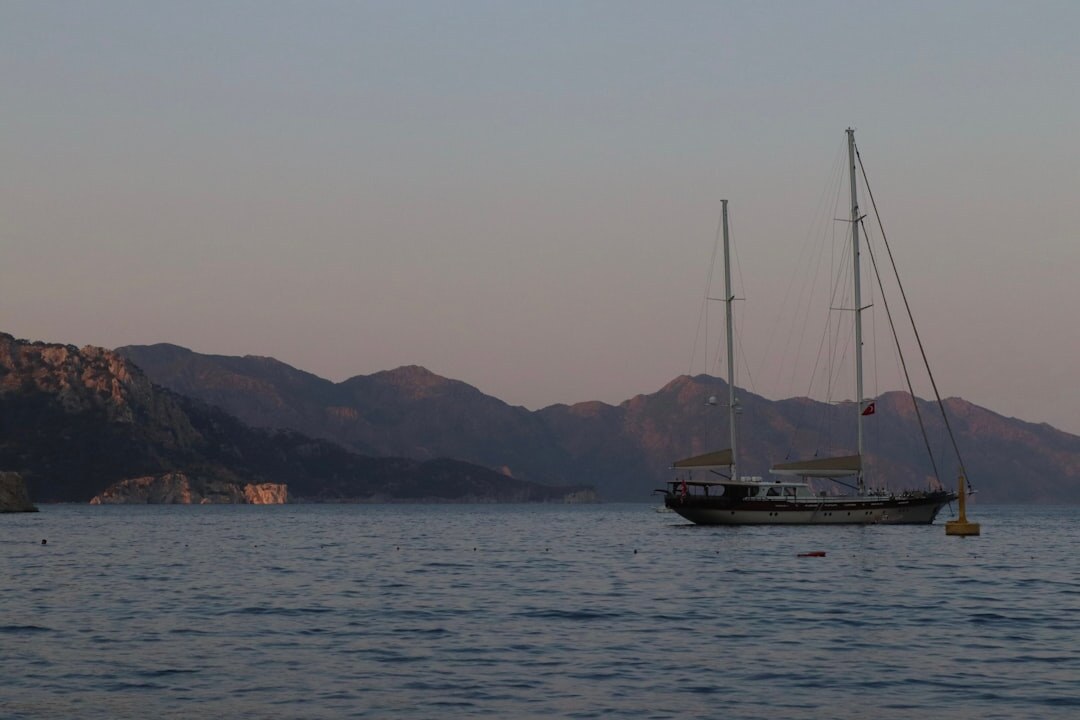 Luxury yacht sailing near the coast at sunset