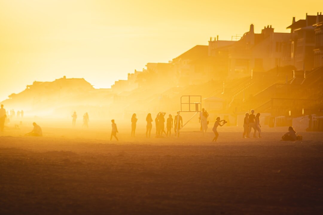 Golden sunset over a beach with silhouettes of people