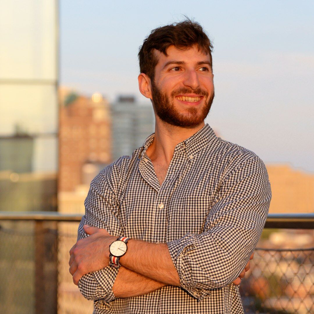 Latino man with short hair smiling in a casual shirt